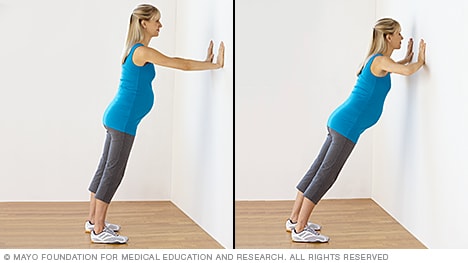 امرأة حامل تمارس تمرين الضغط على الجدار
