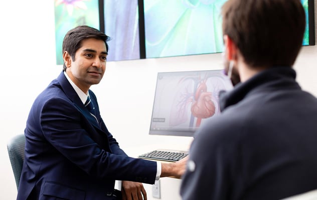 طبيب يراجع صورة للقلب على جهاز الكمبيوتر مع المريض.