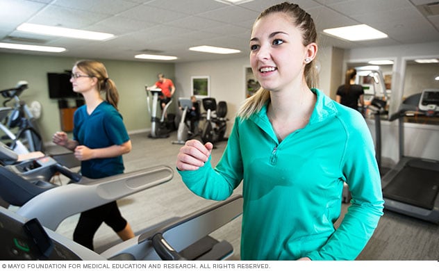 Adolescent participants works with treadmill and elliptical equipment.