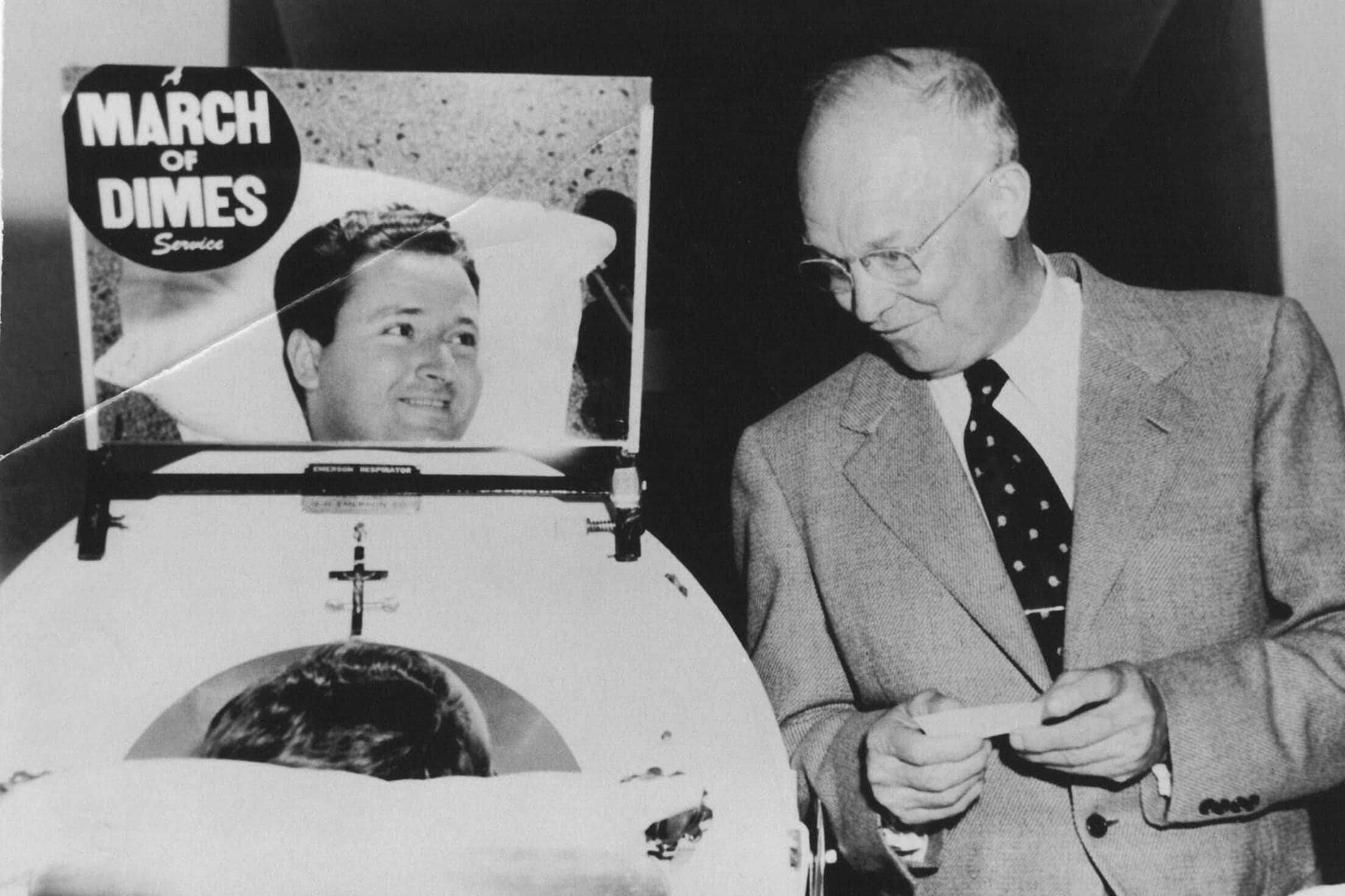 Un hombre con poliomielitis en un pulmón de acero habla con el expresidente Dwight Eisenhower