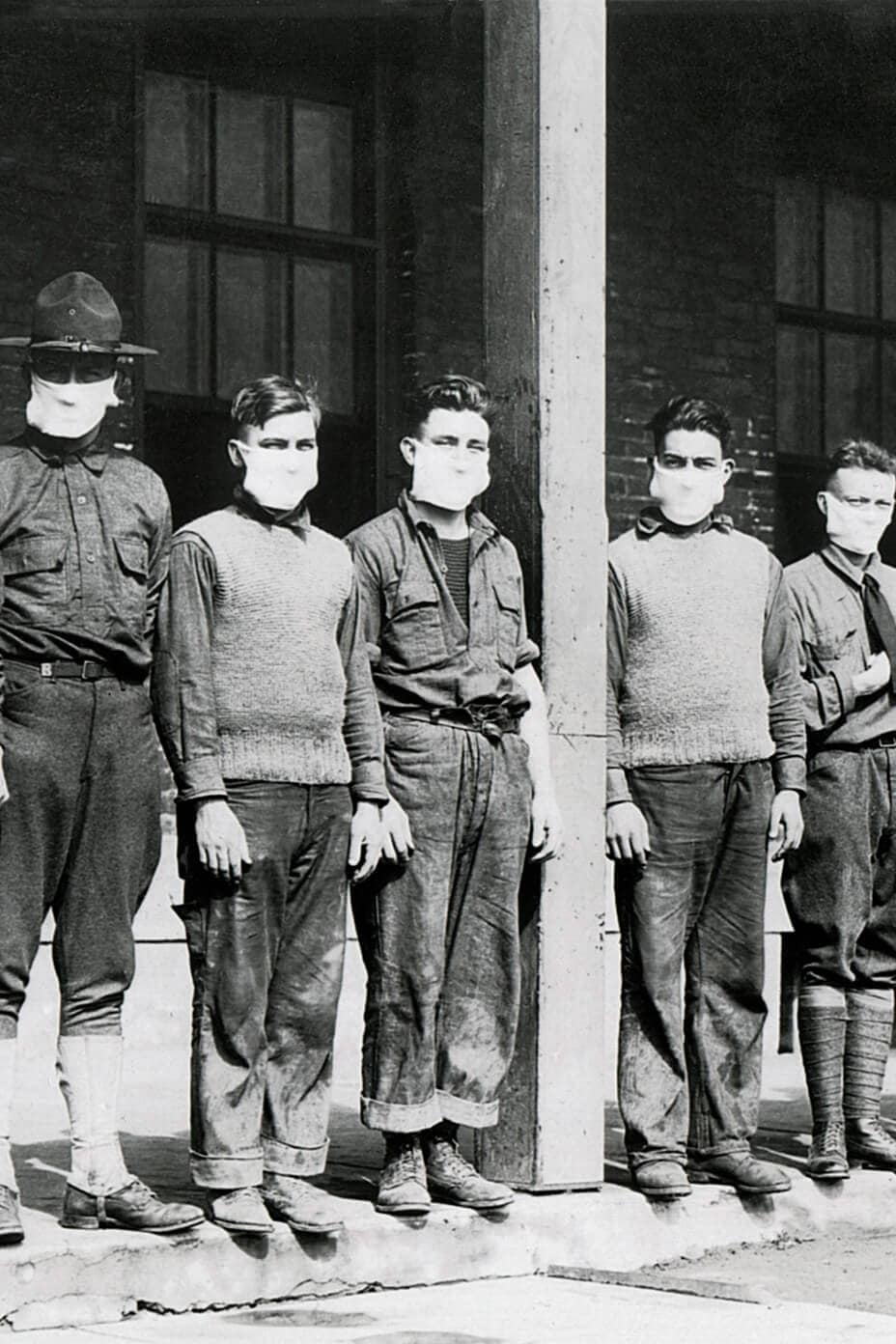 Hombres del ejército de pie con mascarillas durante la pandemia de gripe entre 1918 y 1919