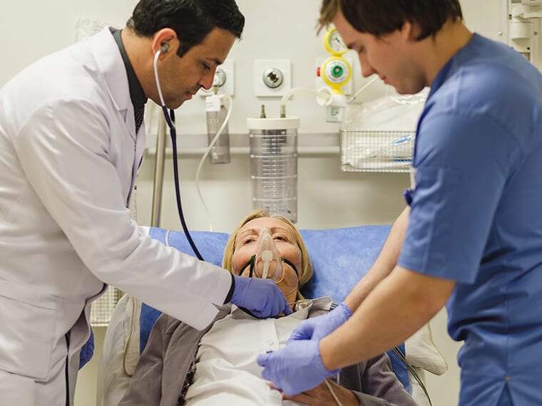 أحد العاملين في المستشفى السعودي الألماني بالقاهرة يشرح لأحد الطاب كيفية تقديم الرعاية لأحد المرضى.