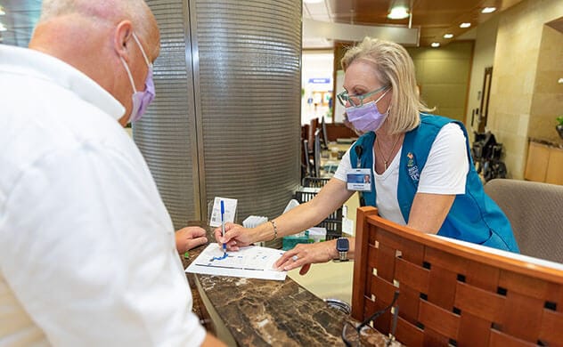 A Mayo Clinic volunteer in Florida provides a visitor with information.