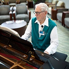 A Mayo Clinic volunteer in Florida plays the piano for visitors.