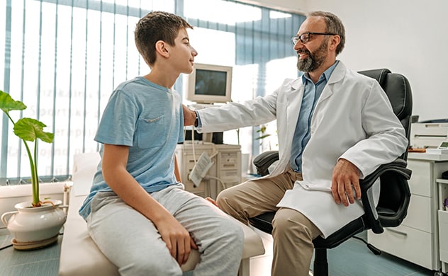 An adolescent confers with a doctor