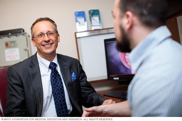 A Mayo Clinic men's health physician chats cheerfully with a patient.