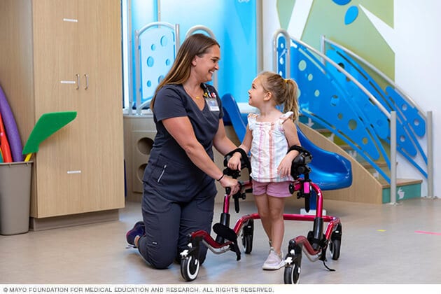 A staff person and young therapy patient smile at each other during a session.