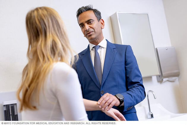 A surgical oncologist discusses a plan of care with a patient.