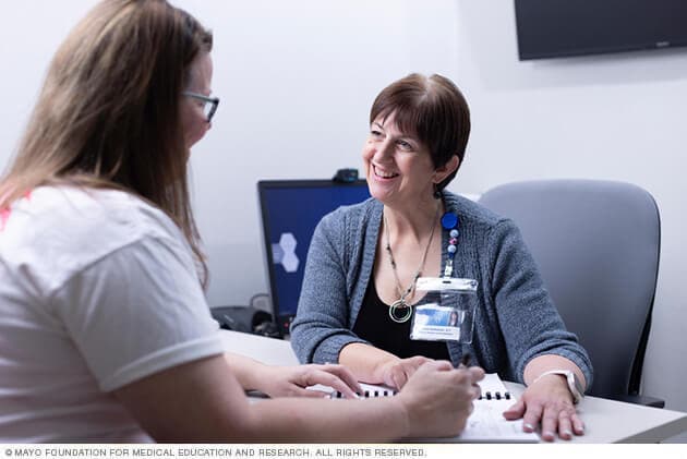 A person in a work injury rehabilitation discusses goals with a therapist.