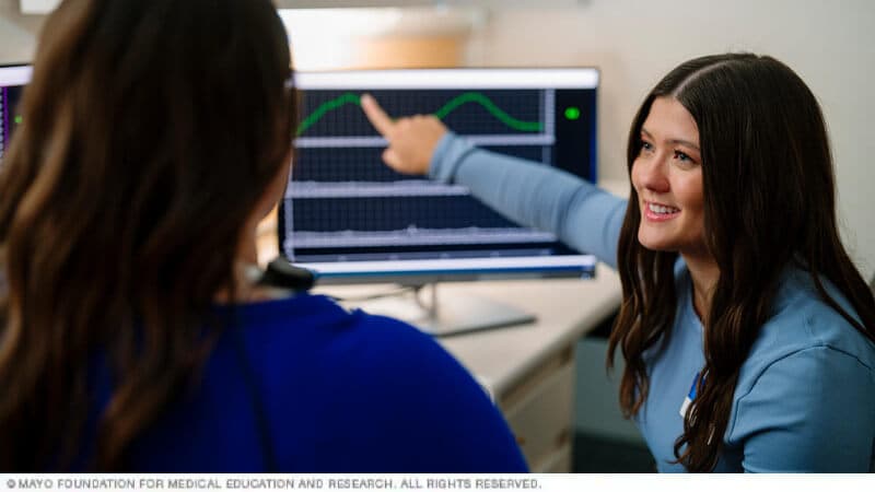 Two participants work with biofeedback equipment.